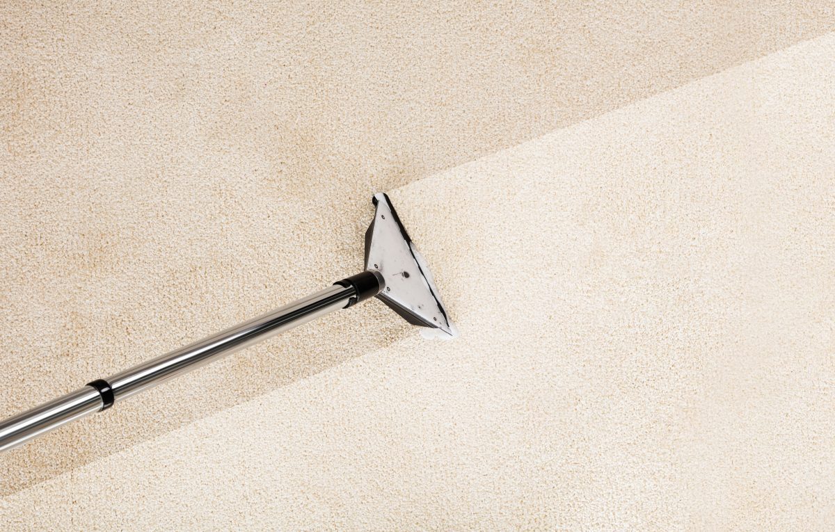 A vacuum cleaning a beige carpet