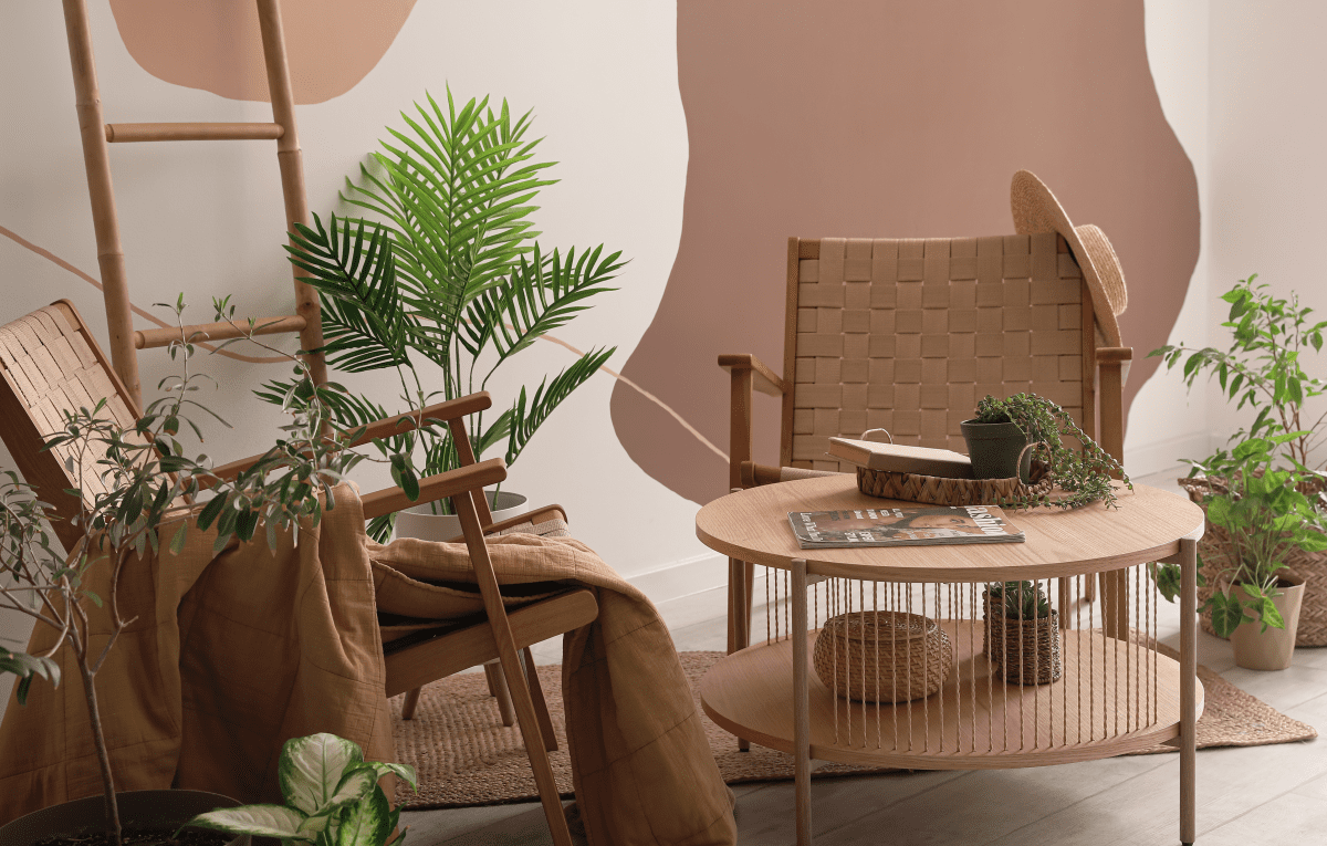 a small living area decorated with light brown furniture and plants