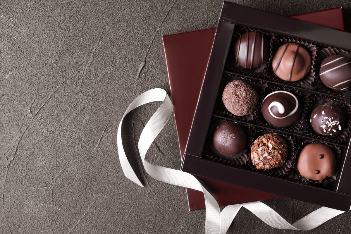 top view of box with chocolate on beige background