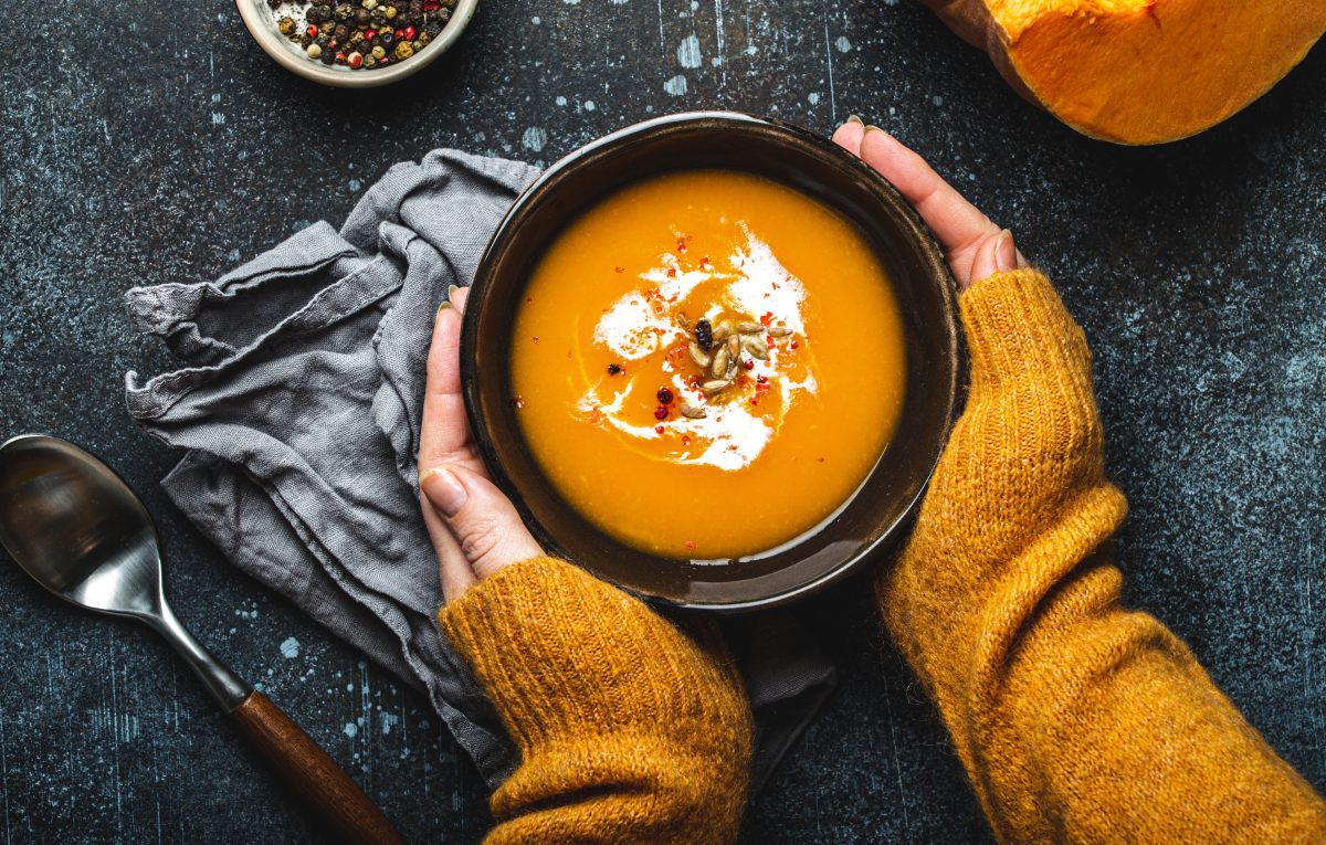 hands holding bowl of soup